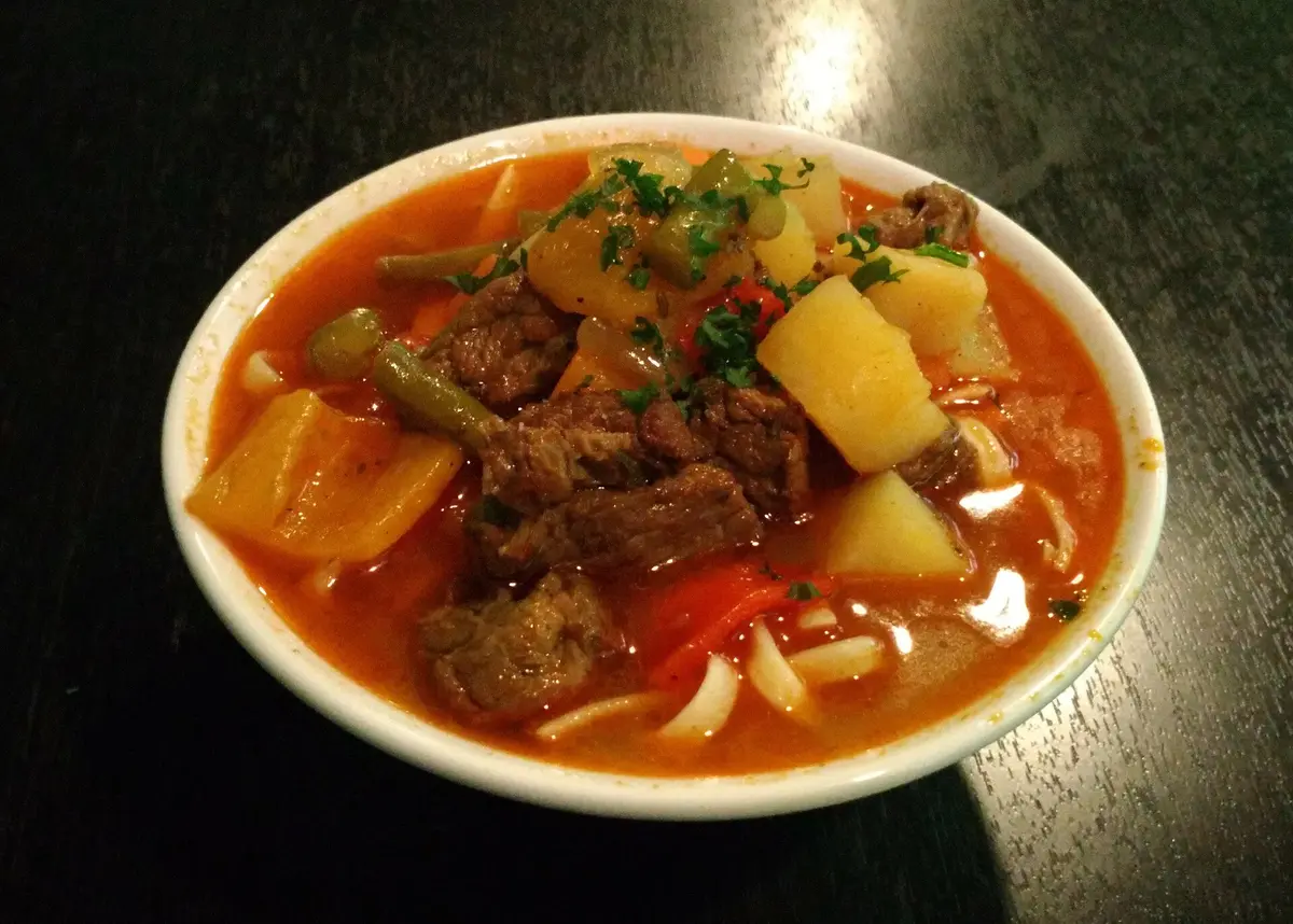 A colorful bowl of Uzbek lagman noodles with beef and vegetables